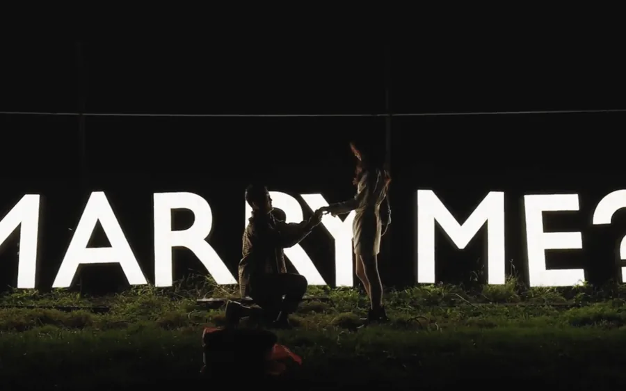 A ring box held against a helicopter window over Manhattan